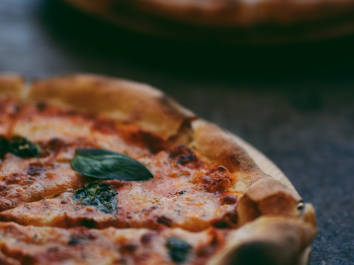 Pizza som lyfts ur ugnen